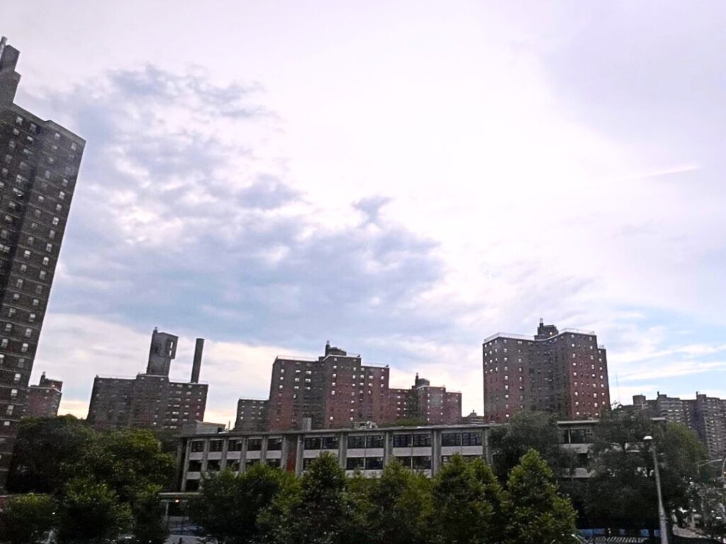 Bernard M. Baruch Houses towers under cloudy sky behind a NYCHA community facility in Manhattan