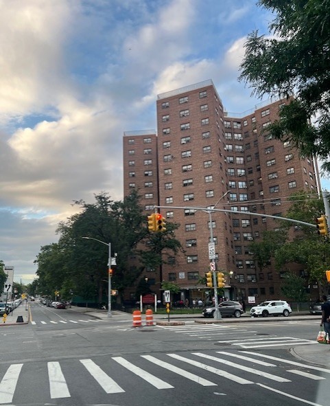 Farragut Houses NYCHA development in Brooklyn, New York, viewed from a street corner with visible pedestrian crosswalks and traffic lights.