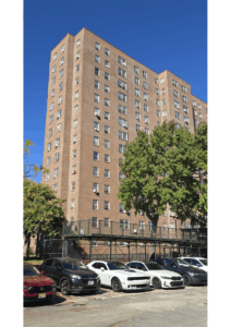 Edenwald Houses NYCHA building exterior in the Bronx with parking area and rooftop fencing